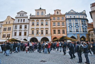 People walking on street against buildings in city