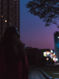 Rear view of woman walking on street at night