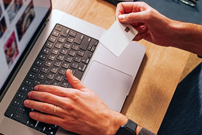Cropped hands using laptop