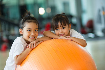 Portrait of girls over fitness ball in gym