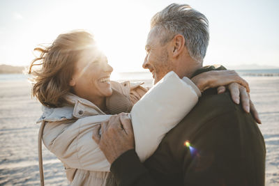 Happy couple enjoying at beach on sunny day