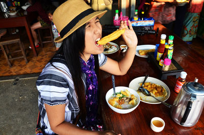 Midsection of woman having food in restaurant