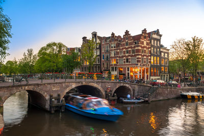 Bridge over river in city against sky