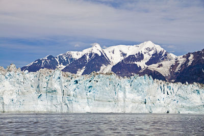 Scenic view of sea and snowcapped mountains against sky