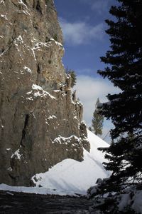 Low angle view of snow on rock against sky