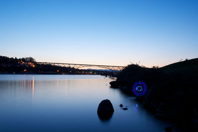 Scenic view of river against clear blue sky at dusk