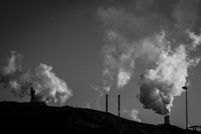 Smoke emitting from chimney against sky