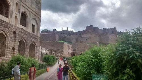 Panoramic view of tourists against cloudy sky