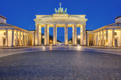 The illuminated brandenburger tor in berlin at dawn with no people