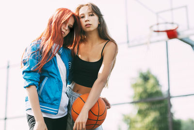 Portrait of two charming girls with a basketball on the sports field. friendship, best friends