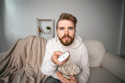 Portrait of man sitting on sofa at home