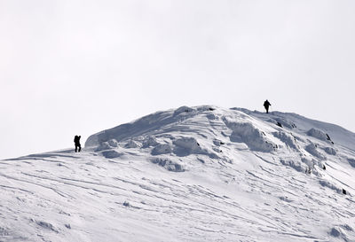 People skiing on snow covered mountain