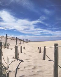 Wooden posts on beach against sky