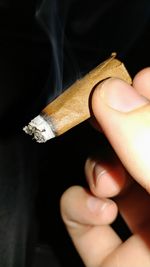 Close-up of hand holding cigarette