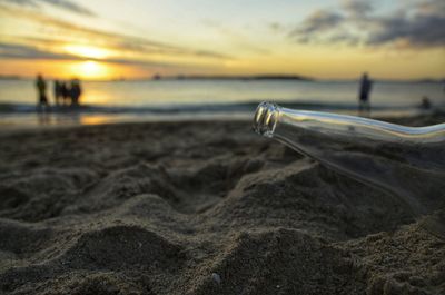 Surface level of beach against sky during sunset