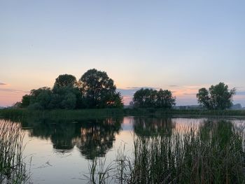 Scenic view of lake against sky at sunset