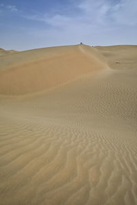 Sand dunes in desert against sky