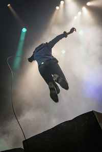 Low angle view of man jumping during concert