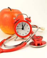 Close-up of clock on table against white background