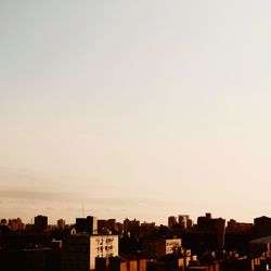 Silhouette buildings in city against clear sky