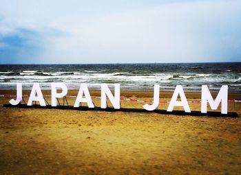 View of text on beach against sky