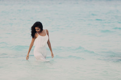 Portrait of young woman standing on beach