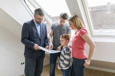 Estate agent explaining family construction plan of a penthouse