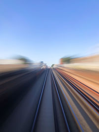 Blurred motion of railroad tracks against clear blue sky