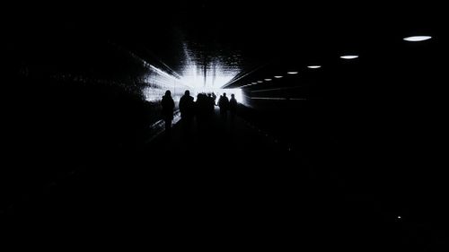 Silhouette people walking in underground walkway