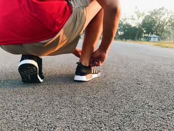 Low section of man skateboarding on road