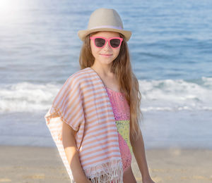 Portrait of young woman standing at beach