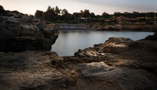 Rock formations by sea against sky