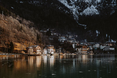 Scenic view of lake by buildings against mountain