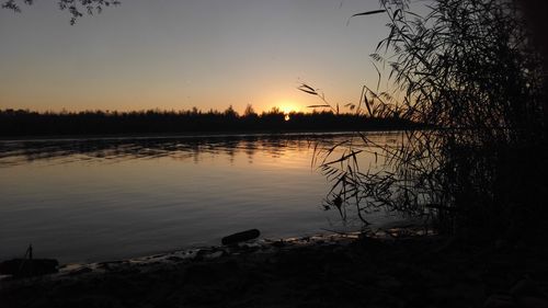 Scenic view of lake against sky at sunset