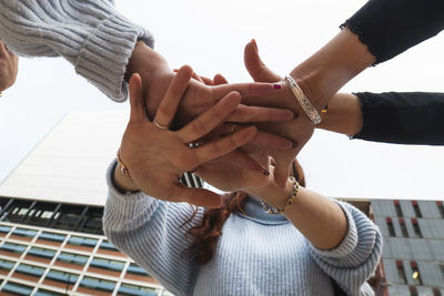 Young female friends stacking hands