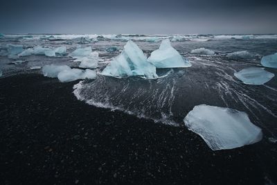 Snow covered landscape with sea in background