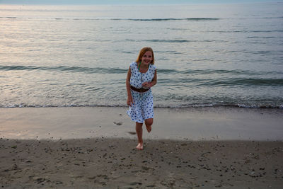 Full length portrait of woman standing on beach