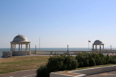 Built structure by sea against clear sky
