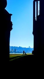 Silhouette people against blue sky