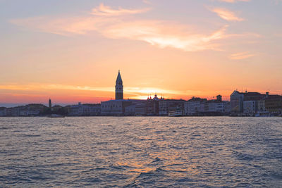 Golden hour, sunset in venice italy, skyline, cityscape from the lagoon, city view, orange sky 