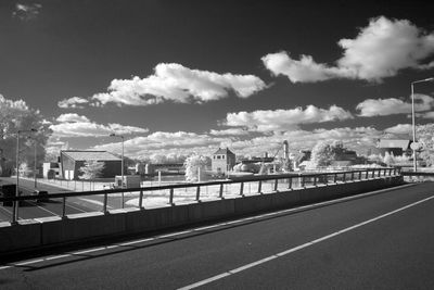 Empty road against cloudy sky