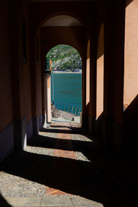 View of sea seen through arch door of building