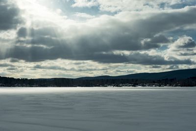 Scenic view of snow covered land against sky