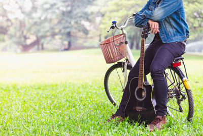 Full length of woman with bicycle on field