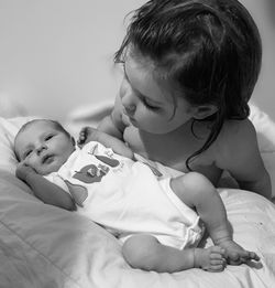 Cute baby girl lying on bed at home