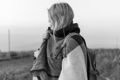 Woman in warm clothing standing against sky