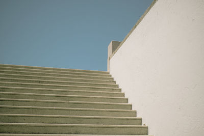 Low angle view of empty staircases against clear blue sky