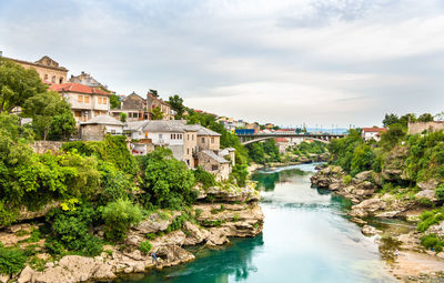 River amidst buildings in city against sky