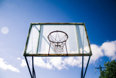 Basketball court against trees and blue sky