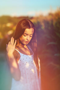 Young beautiful woman in white dress in corn field. surreal blurry portrait